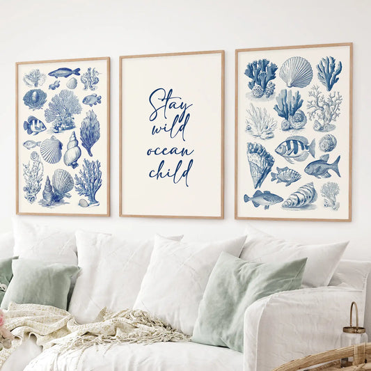 Set of 3 coastal wall art prints with blue sea life illustrations and 'Stay wild ocean child' quote. Thinwood frames over the couch.