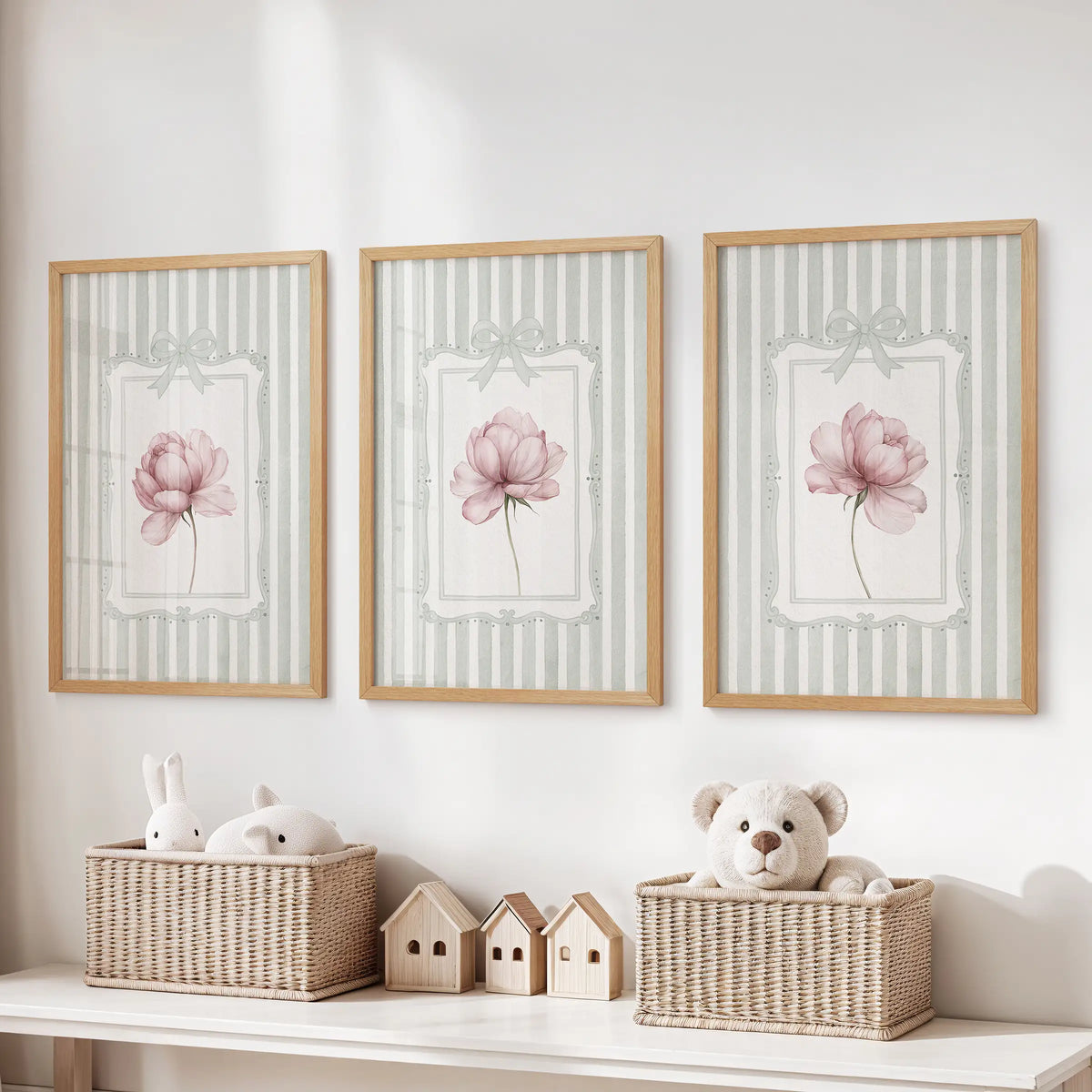 Three-piece vintage floral wall art set in thin wood frames, with pink flowers on sage green stripes over a playroom toy storage bench.