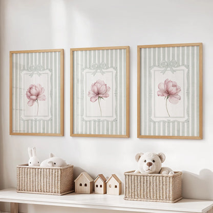 Three-piece vintage floral wall art set in thin wood frames, with pink flowers on sage green stripes over a playroom toy storage bench.