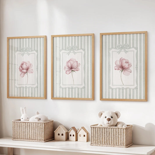 Three-piece vintage floral wall art set in thin wood frames, with pink flowers on sage green stripes over a playroom toy storage bench.