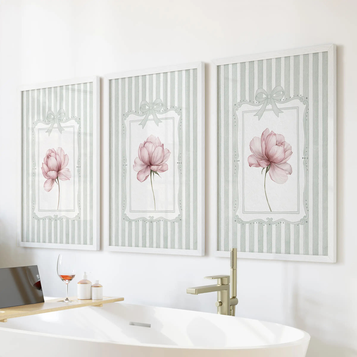 French country floral wall art set of three in white frames, showing pink peonies on sage striped backgrounds over a freestanding bathroom tub.