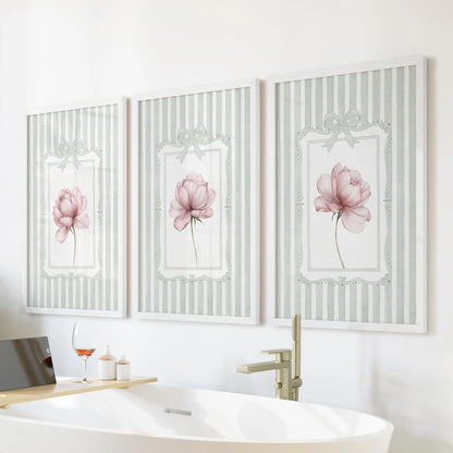 French country floral wall art set of three in white frames, showing pink peonies on sage striped backgrounds over a freestanding bathroom tub.