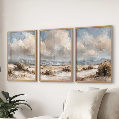 Moody vintage landscapes, a 3-poster bundle in solid oak frames, elevate the living room with coastal-and-country calm, spanning the wall above the sectional.