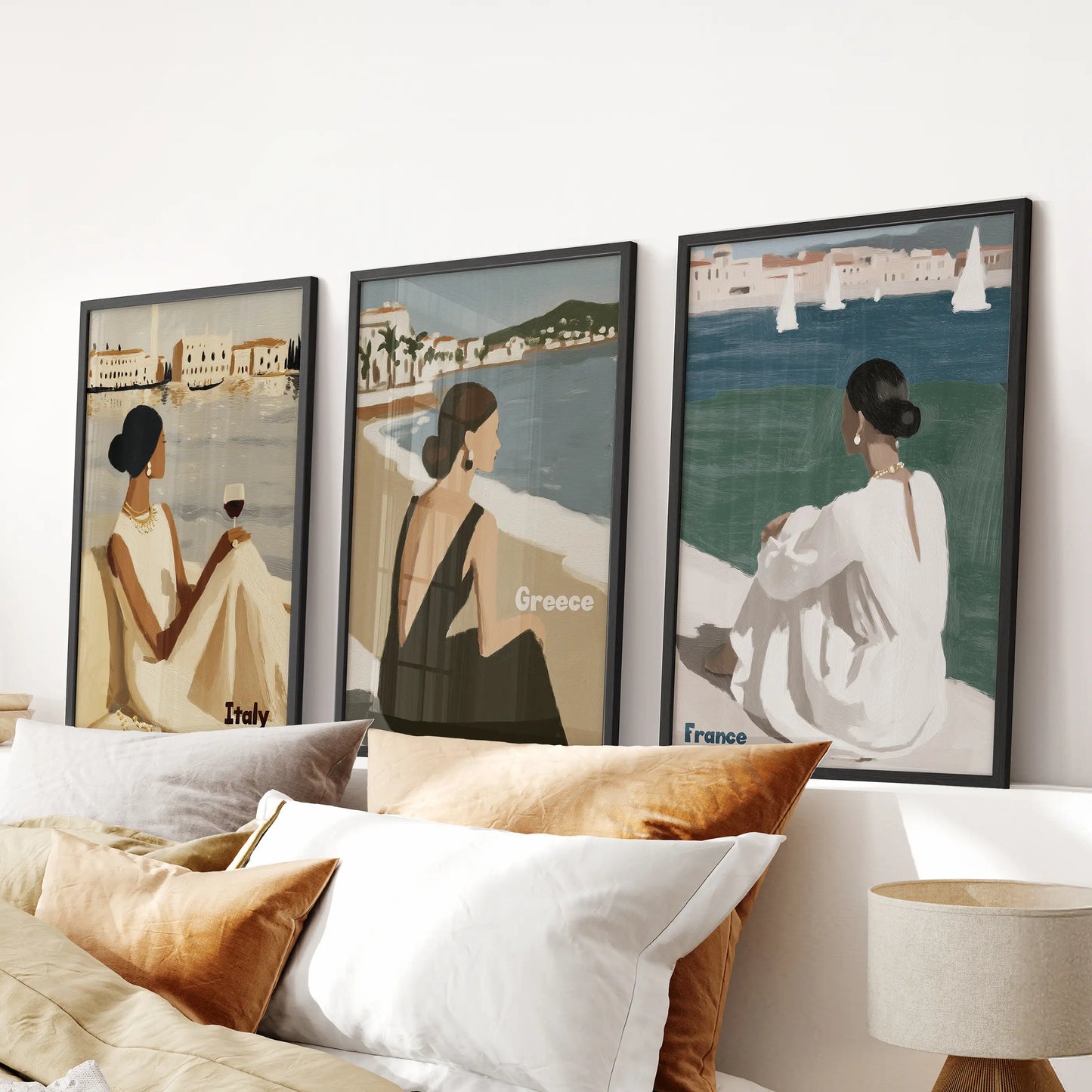 Black-framed posters of coastal lifestyle scenes, a set of three, rest above the bedroom headboard and brighten the décor with seaside calm.
