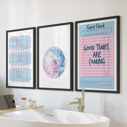 This playful trio of wall art in black frames hangs above the tub, mixing a disco ball, guest check, and beach ticket for a preppy bath look.