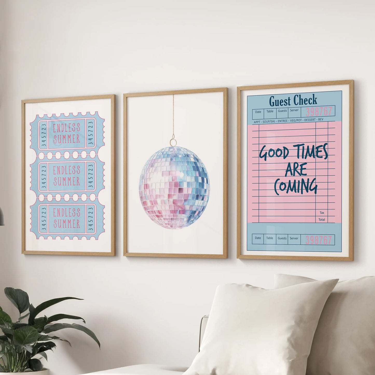 Preppy blue and pink coastal set of three prints in thin wood frames hangs over the couch, blending disco ball sparkle with ticket and guest check ephemera.