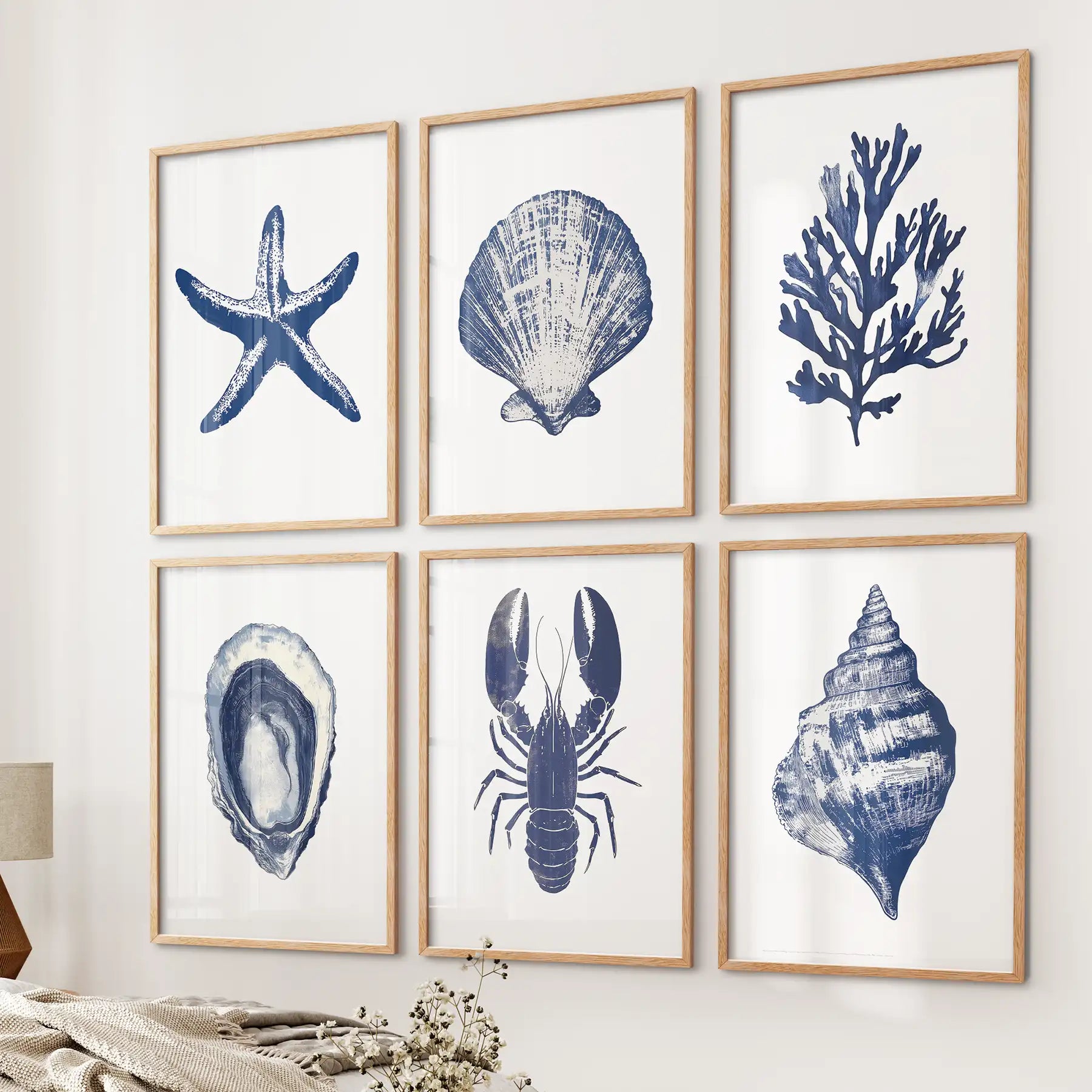 Blue ocean themed illustrations. Trendy coastal gallery wall set of 6 piece. Thinwood frames above the bed. 