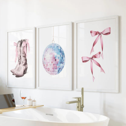Blue-and-pink preppy poster triptych, white-framed and set over the tub wall, brings airy beachy wall art energy to a clean, light bathroom.