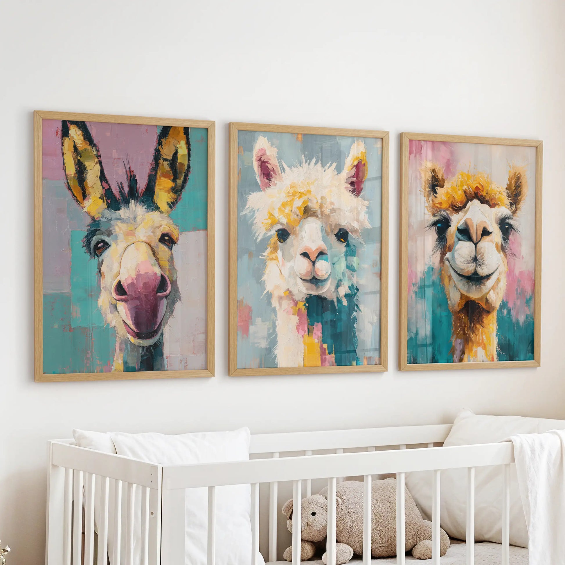 Three oak-framed donkey art prints sit above the cot, bringing gentle color and a cheerful focal point to the nursery.