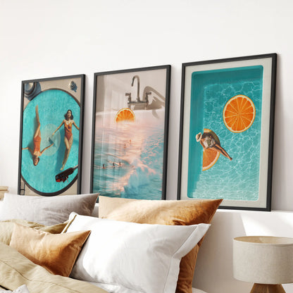 Three black-framed collage prints in coastal blues and oranges form a crisp, modern wall art accent above the bedroom headboard.