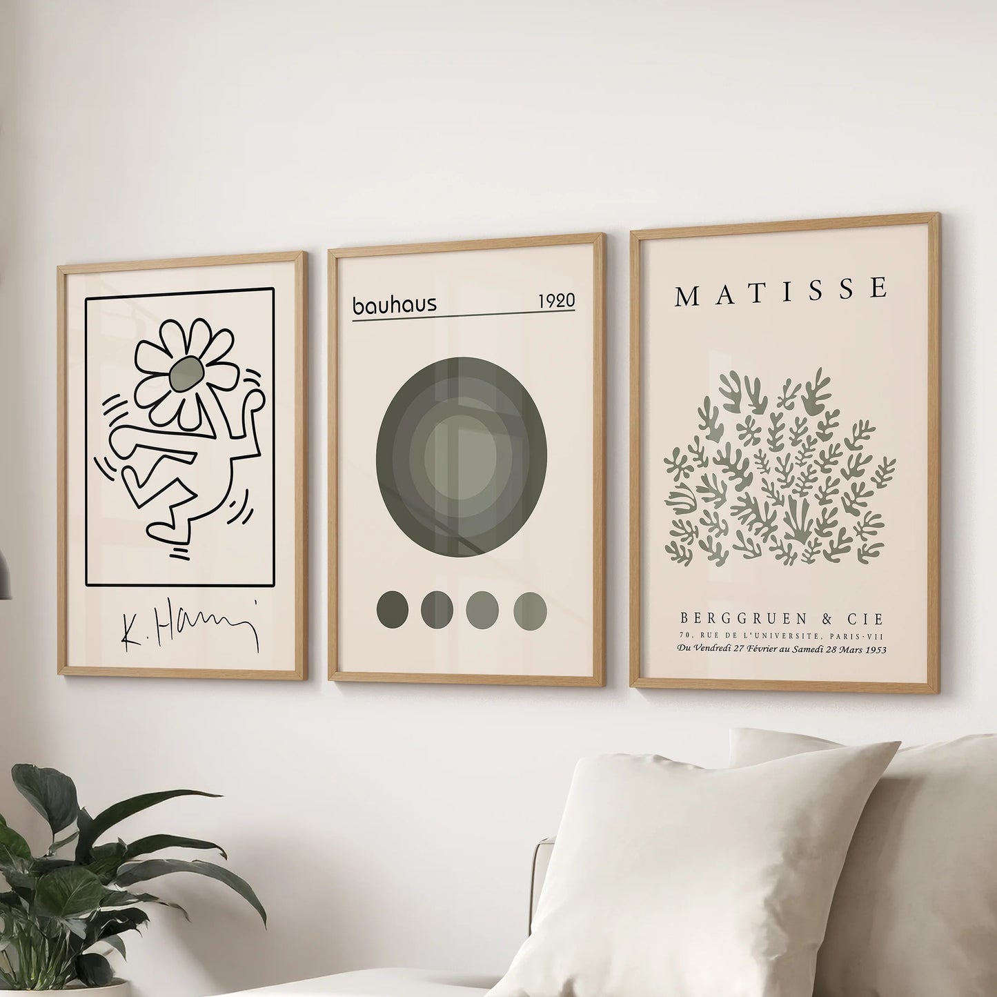 Set of three contemporary posters framed in solid oak align over the lounge couch, forming a sharp and cohesive modern display.