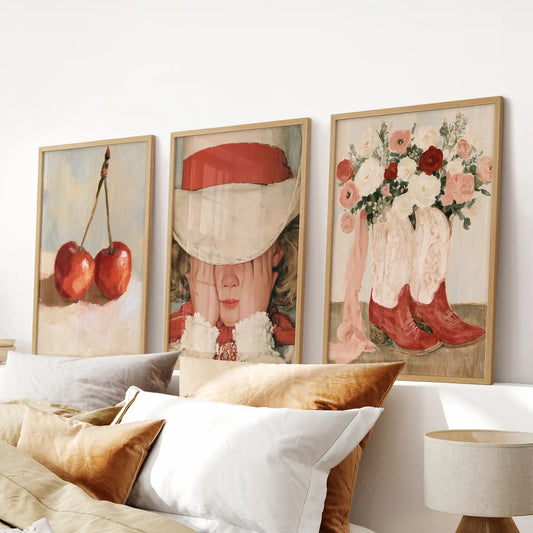 Cherry fruit art forms a three-piece wall set in natural wood frames, centered over the bedroom bed with a cozy, inviting feel.