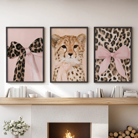 A trio of framed posters featuring preppy coquette animal art hangs in black frames over the hearth, giving the family room a crisp editorial pop.