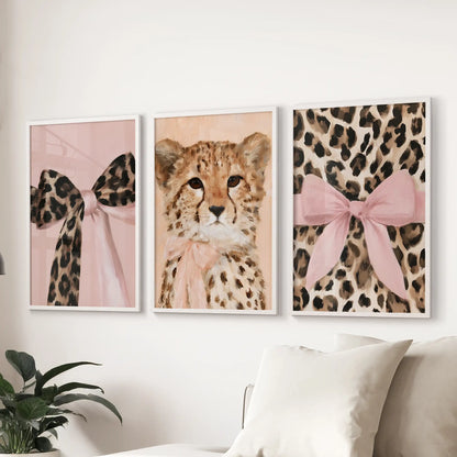 A three-print wall series of leopard and cheetah art spans the sectional sofa in white frames, creating an airy focal stripe in the living room.