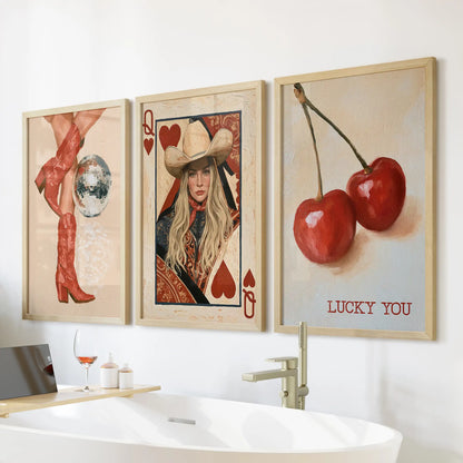 Three red cowgirl boots art prints in light wood frames hang above the bathtub, pairing girly Western charm with a spa-bright bathroom look.