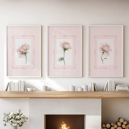 Three-piece pink rose wall art set in white frames, hanging over the mantelpiece in a living room.