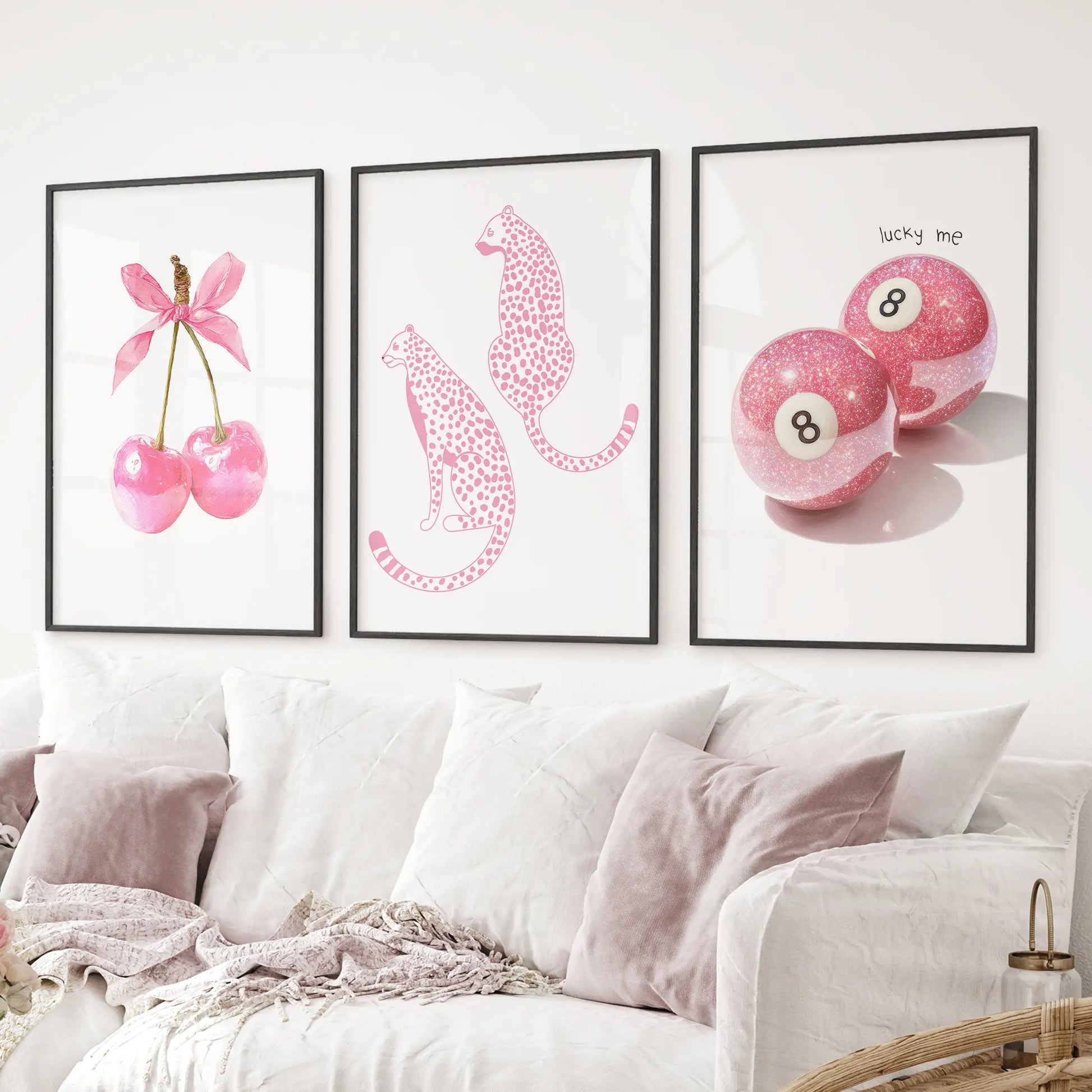Glam pink wall decor trio cherries with bow, cheetah illustrations, and sparkling billiard 8-ball artwork. Black frames above the sofa.
