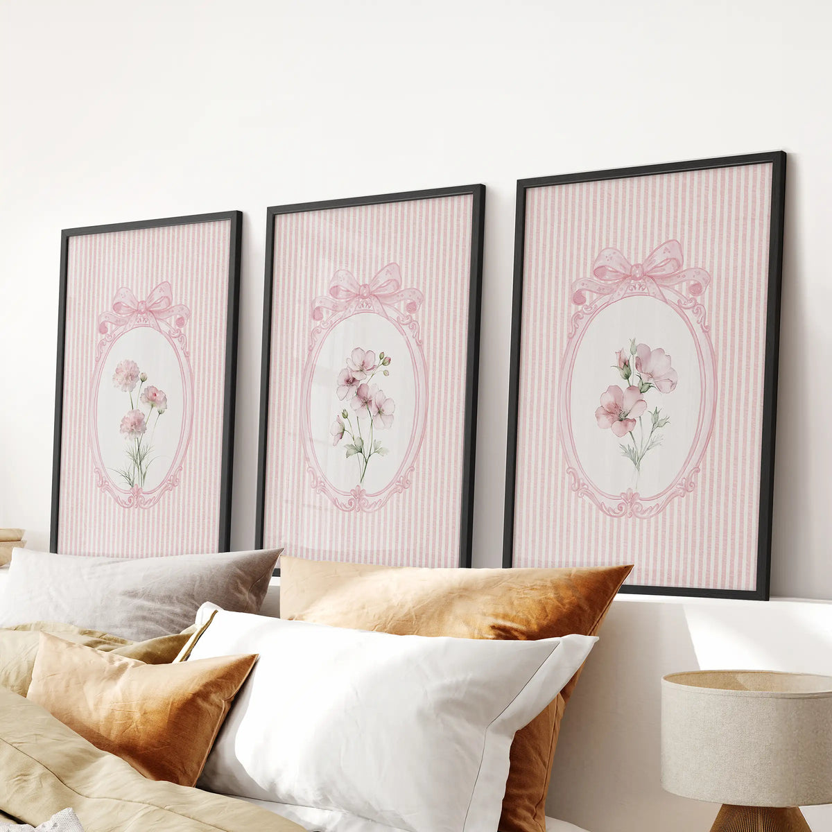 Cottagecore floral prints in a three-piece wall art set, shown in black frames above the bedroom headboard.