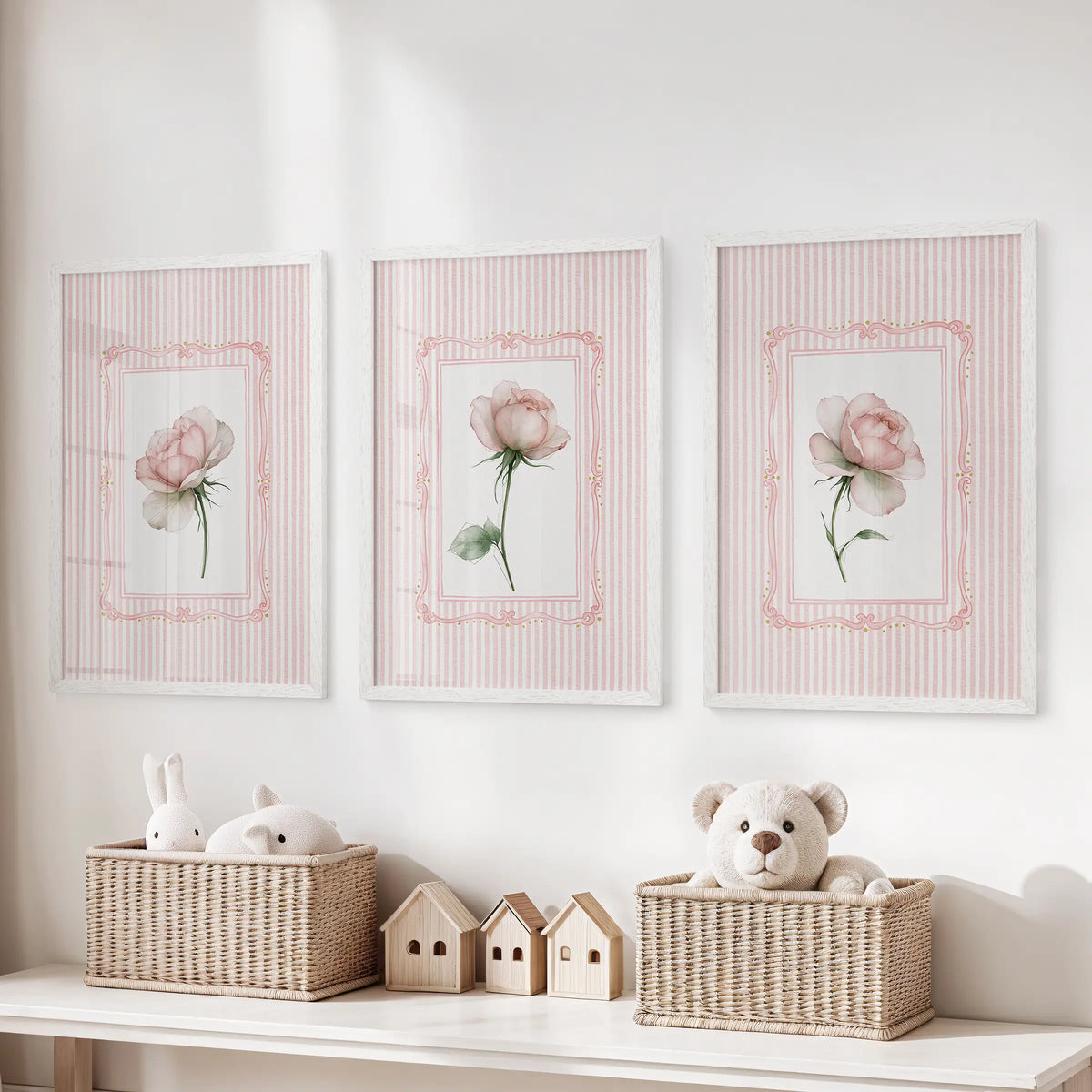 Three-piece rose botanical wall art set in white frames, displayed above toy storage in a playroom.