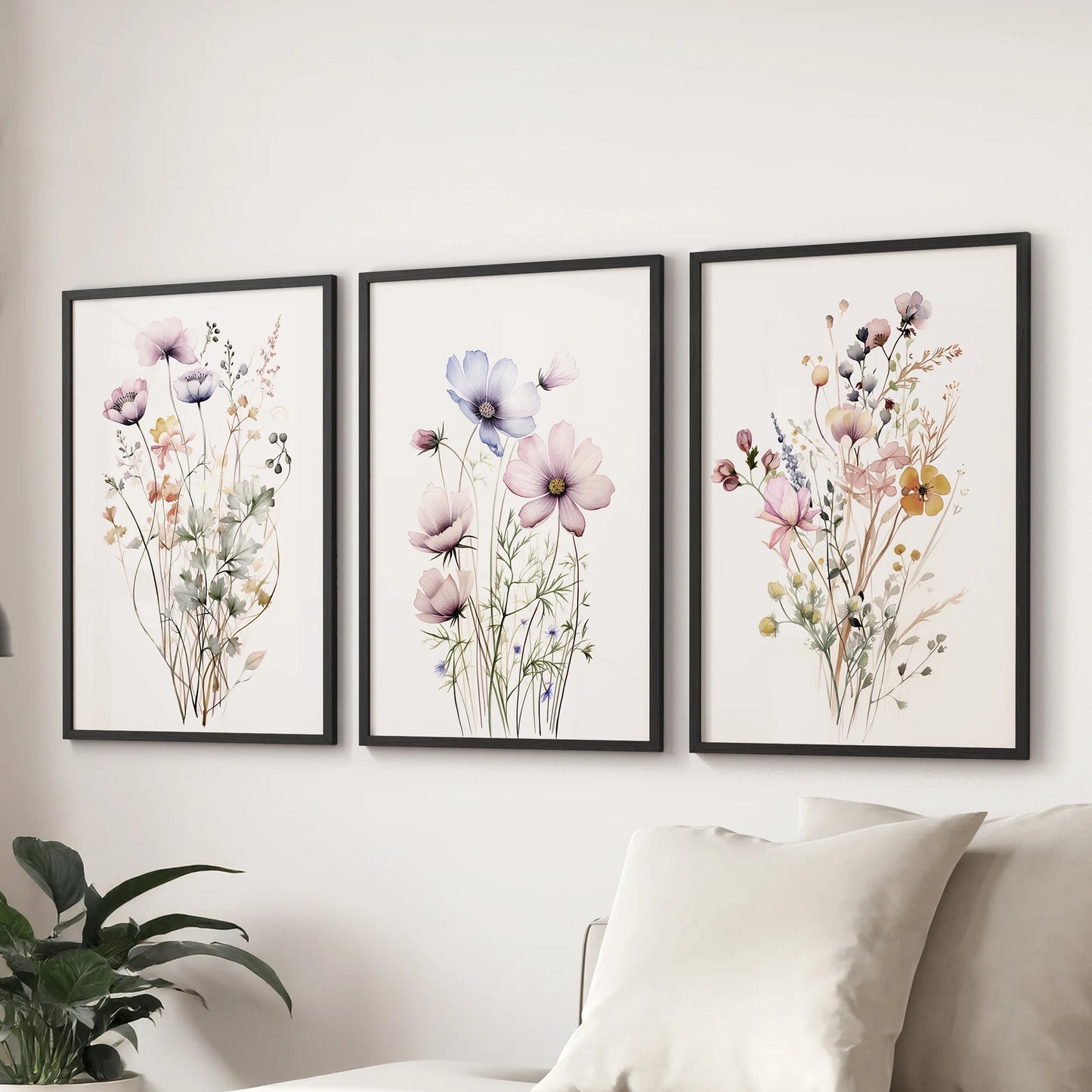 A three-piece botanical picture set in black frames rests above the family-room sofa, lending soft cottage-garden charm and balance.