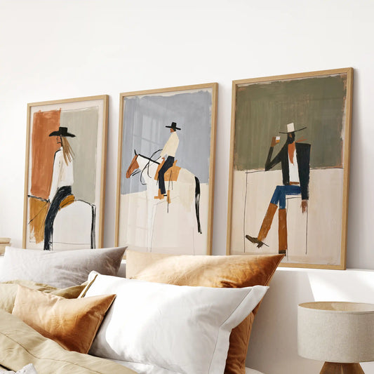 Three-piece framed wall art of a cowboy on horseback, set in oak wood frames above the bedroom headboard for a rugged, calm presence.