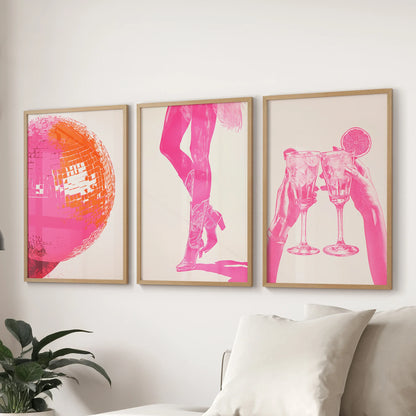 Three collage-style pink prints in light wood frames line the wall behind the sofa, infusing the family room with fresh, rosy energy.
