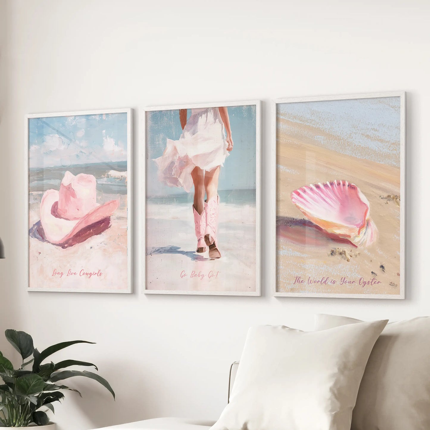 A white-framed three-piece art print set of a vintage pink beach scene hangs behind the sofa, washing the lounge in faded coastal hues.
