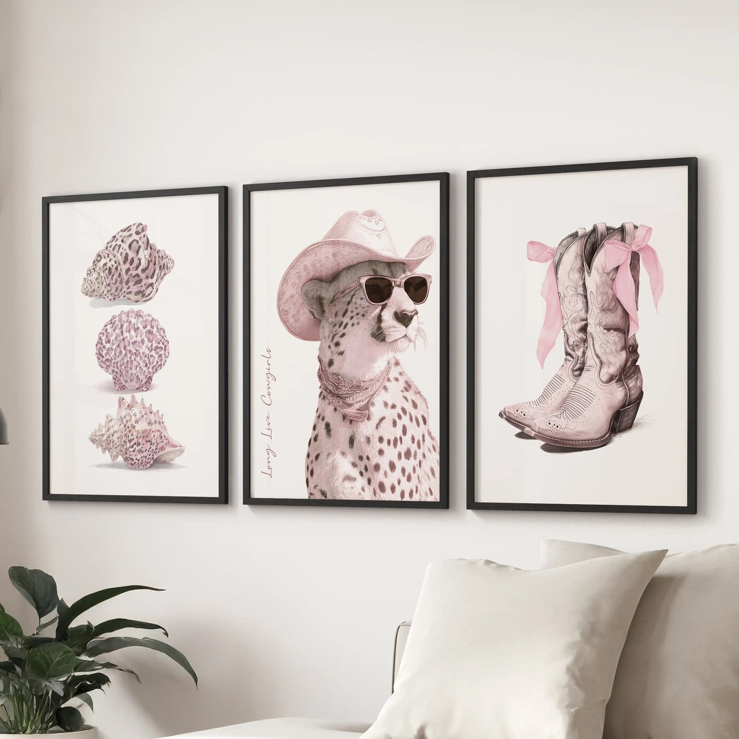 Three black-framed posters with bold lettering and pink details hang above a lounge sectional, celebrating cowgirl spirit with graphic charm.