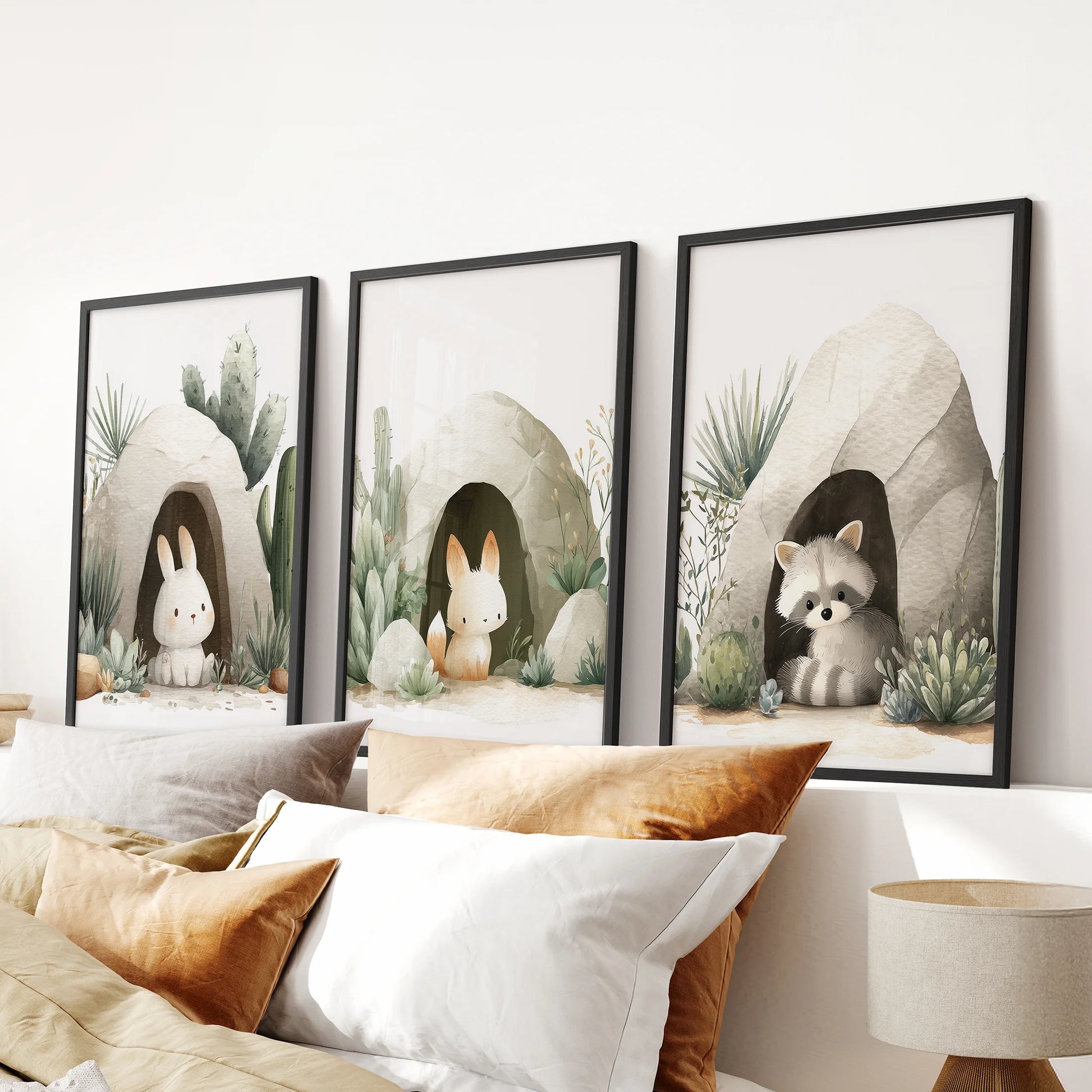 Scandinavian baby room art: white frames with rabbits and a raccoon among cactus and soft greenery.