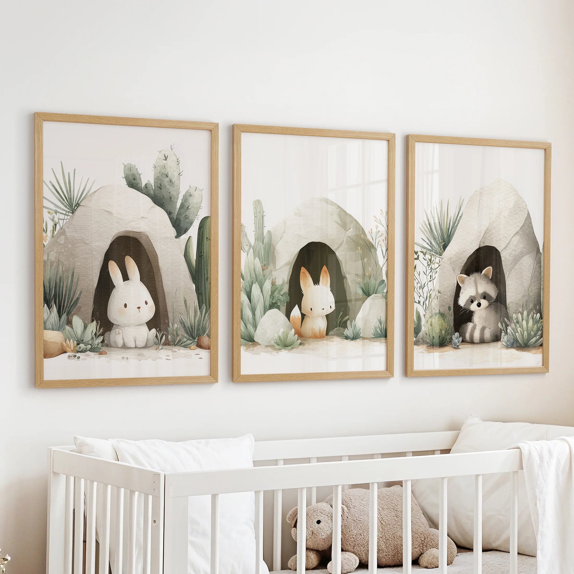 Gender-neutral nursery wall art set of 3 with rabbits and raccoon in desert caves, soft beige and sage tones.