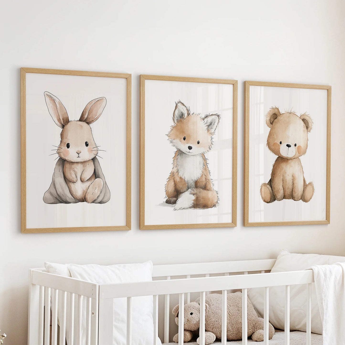 Natural wood framed wall art in three pieces, showing baby animals, hangs above the cot to soften a calm nursery room.