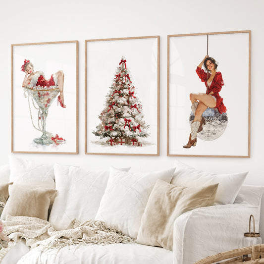 Christmas wall art set of 3 – pin up girl in martini glass, decorated Christmas tree, woman on disco ball. Thinwood frames over the couch.