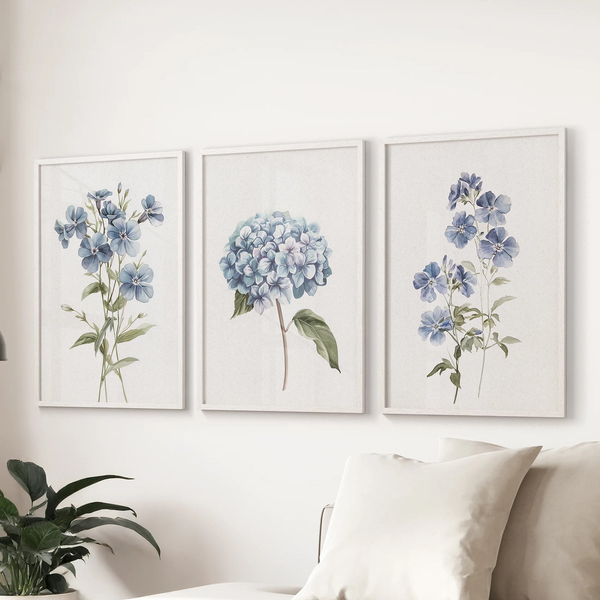 Hydrangea bouquets, a set of 3 white-framed prints, style the sitting room over the sofa with classic blue blooms and soft watercolor detail.