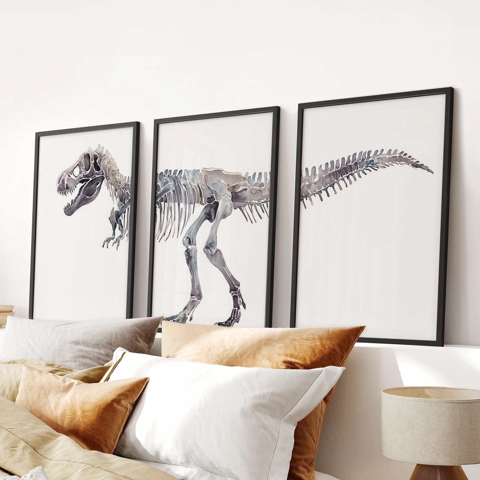 Three-piece dinosaur skeleton wall hanging in black frames sits over the headboard, giving the bedroom a sharp, museum-style focus.