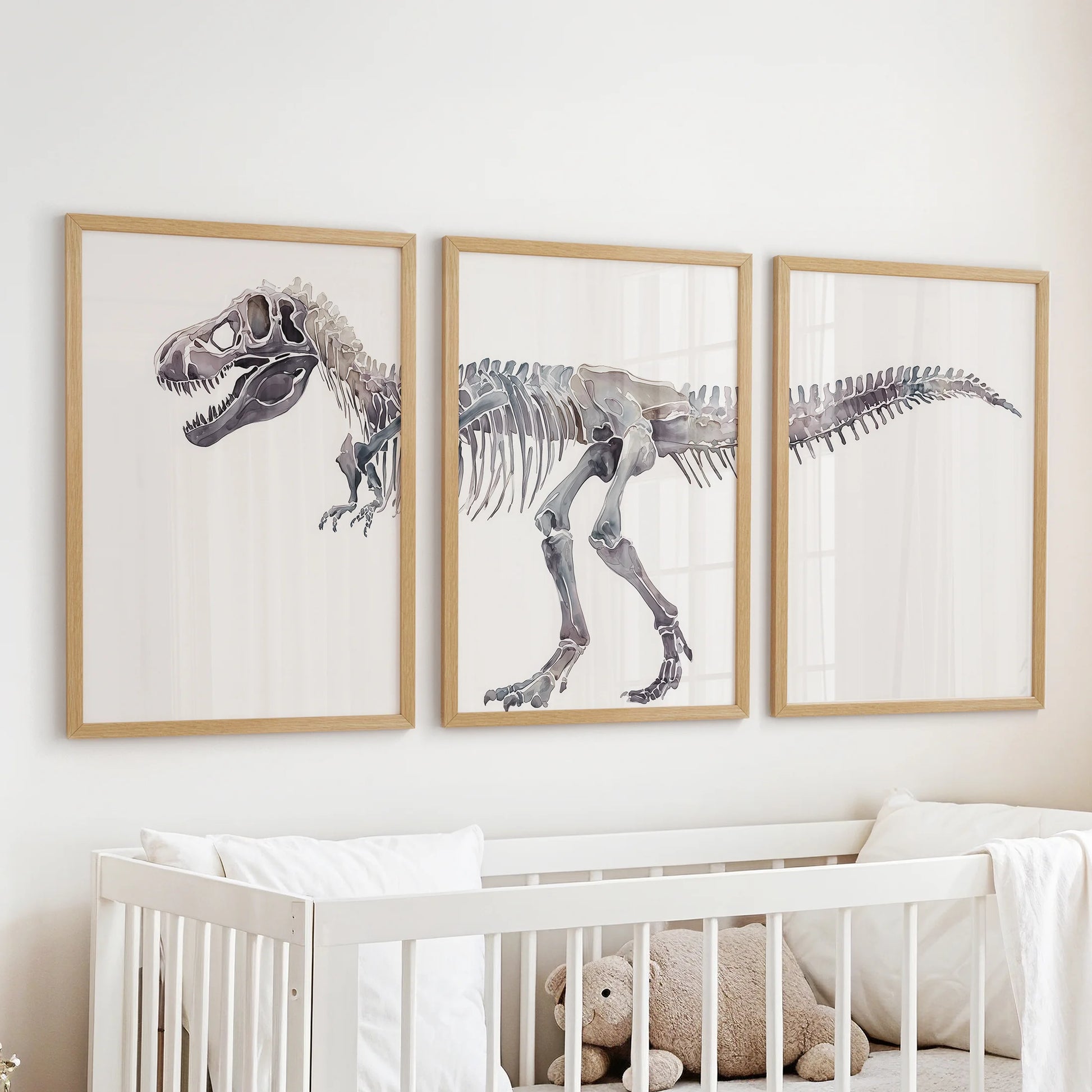 A wall art three-piece set of dinosaur bones in natural wood frames hangs over the cot, lending the nursery a quiet, fossil-story charm.