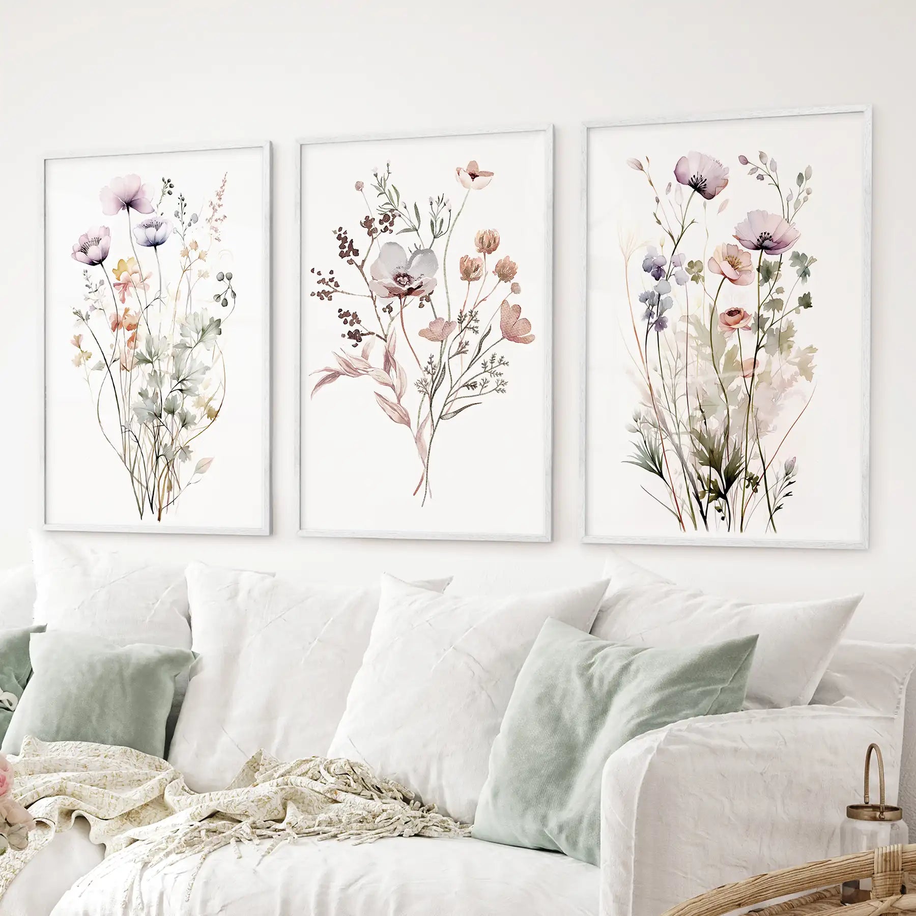 Elegant 3 piece wildflower art set in pastel tones watercolor poppies and anemones. White frames above the sofa.