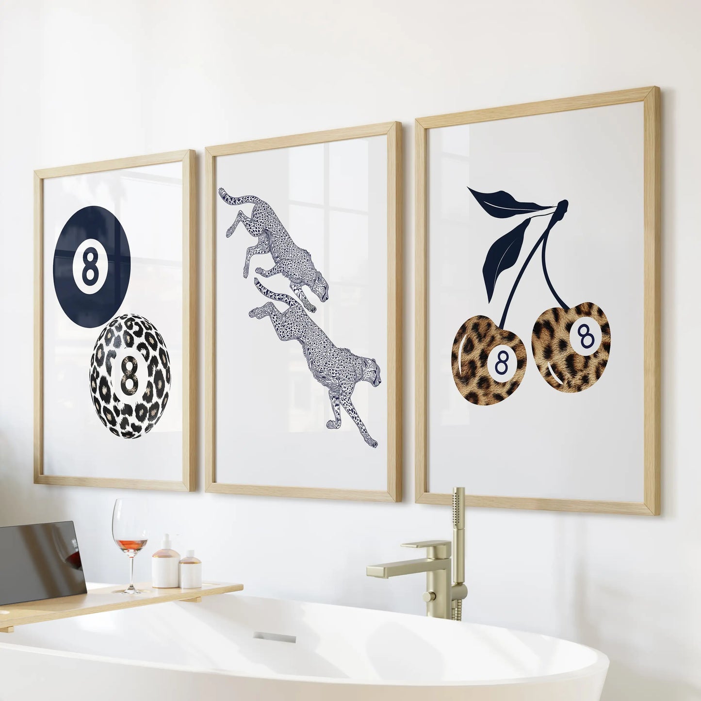 Three eight-ball posters in slim wood frames offer a retro accent as bathroom wall art above the bathtub.