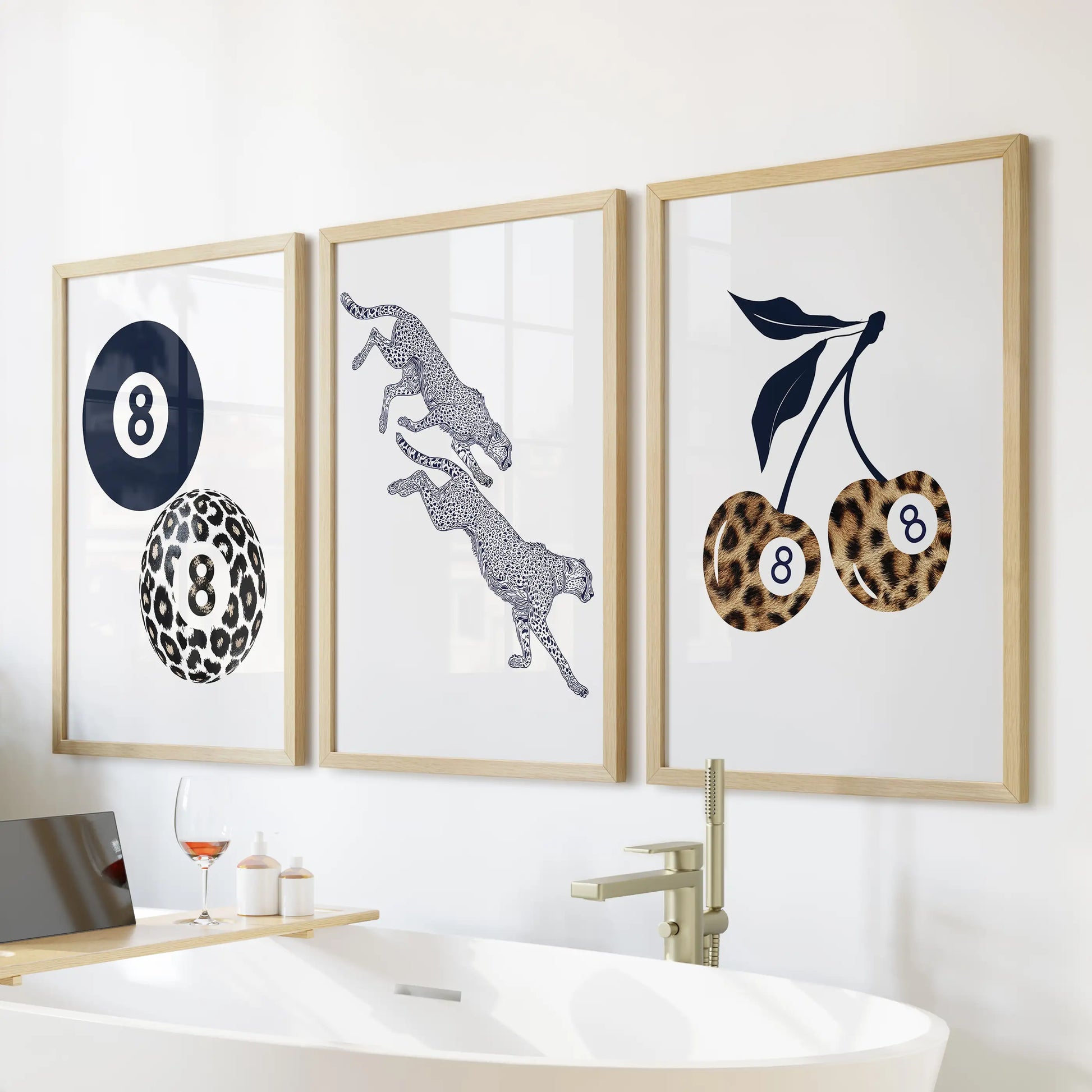 Three eight-ball posters in slim wood frames offer a retro accent as bathroom wall art above the bathtub.