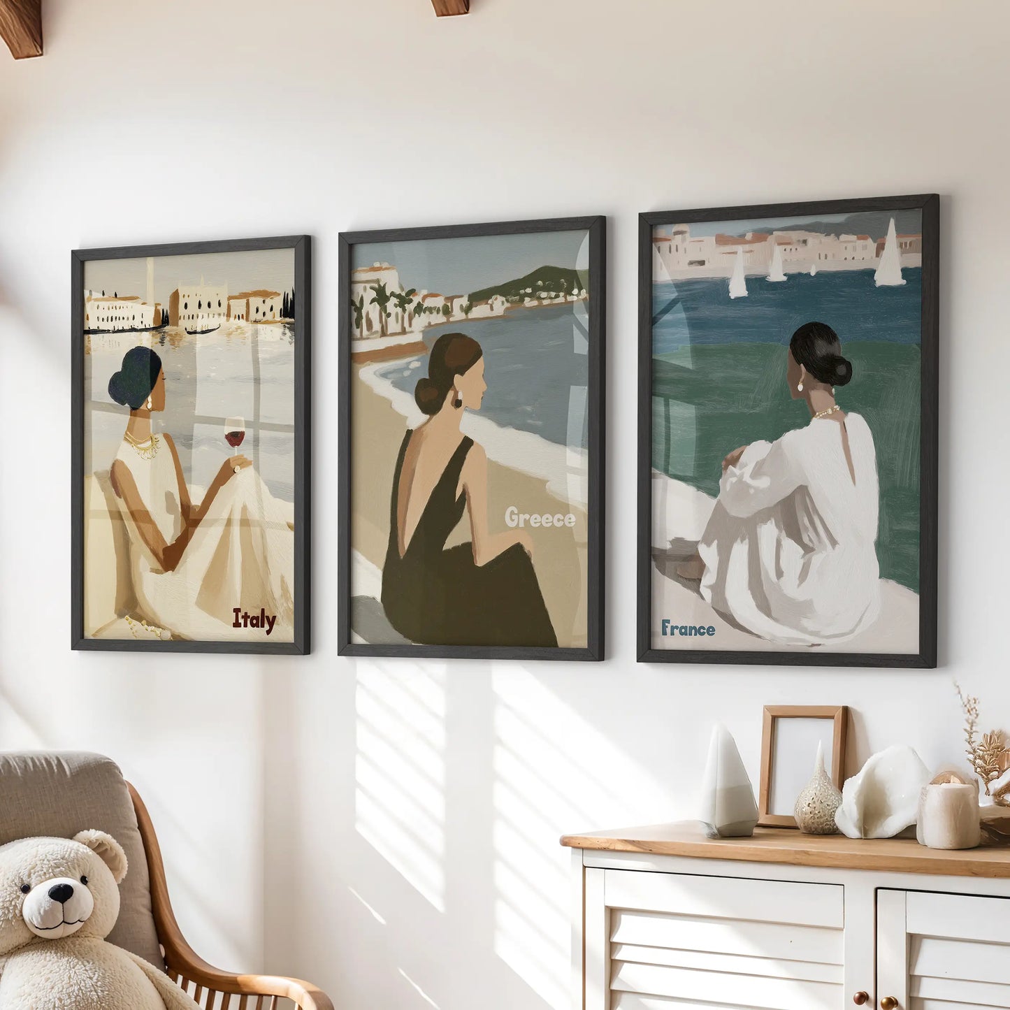Elegant female figures three piece wall decor in sleek black frames hangs over the playroom chest of drawers, lending airy, fashion-forward coastal charm.