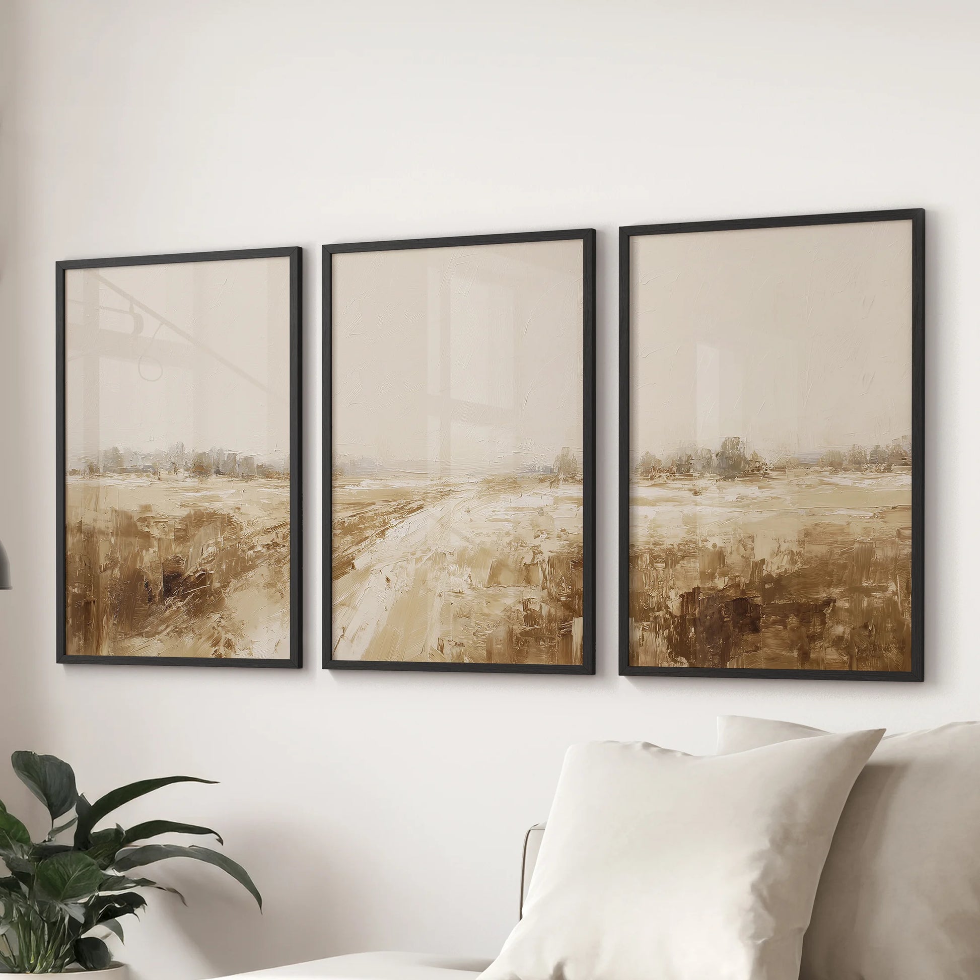 Beige earth-tone countryside prints, a 3-piece wall art set, are black-framed and anchor the family room wall over the sectional.