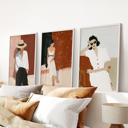 Three elegant women portraits in white frames align above the bed, lending the bedroom a serene glow through refined art prints.