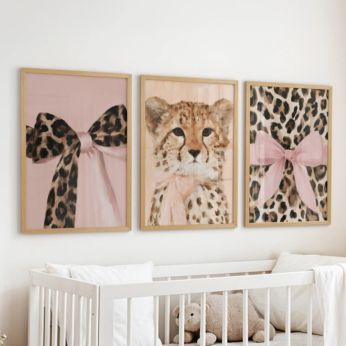 Cheetah and leopard art trio, a three-piece gallery in slim wood frames, floating above the cot to add gentle, friendly energy to the infant room.