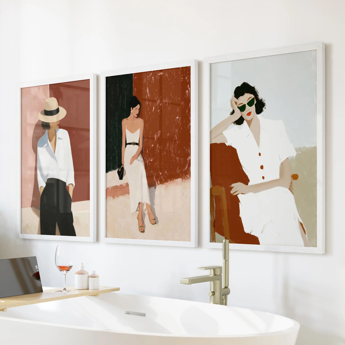 Fashion illustration of modern women, a 3-piece wall art trio in white framed prints, hangs above the bathtub to freshen the bathroom.