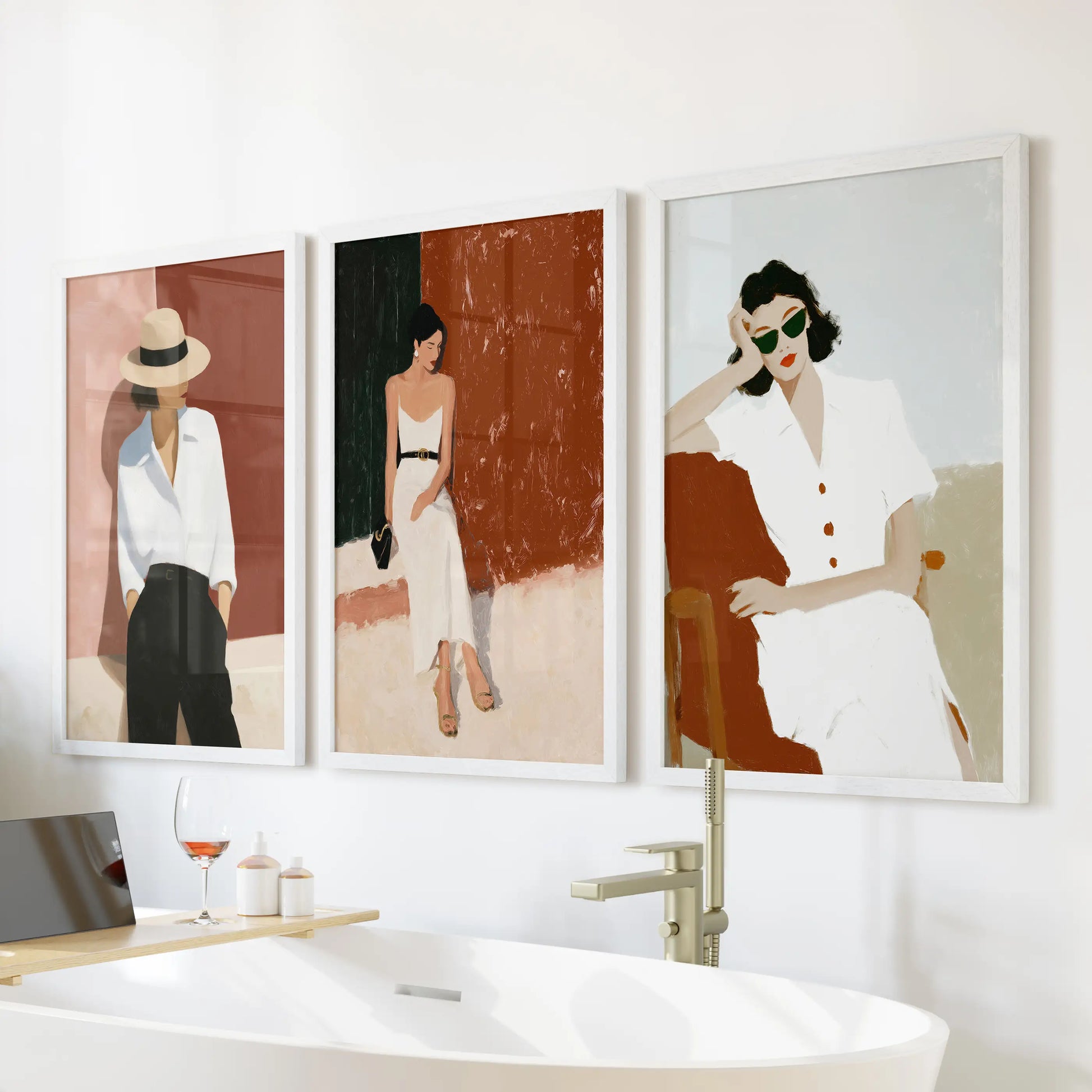 Fashion illustration of modern women, a 3-piece wall art trio in white framed prints, hangs above the bathtub to freshen the bathroom.