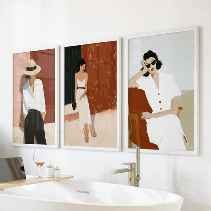 Fashion illustration of modern women, a 3-piece wall art trio in white framed prints, hangs above the bathtub to freshen the bathroom.
