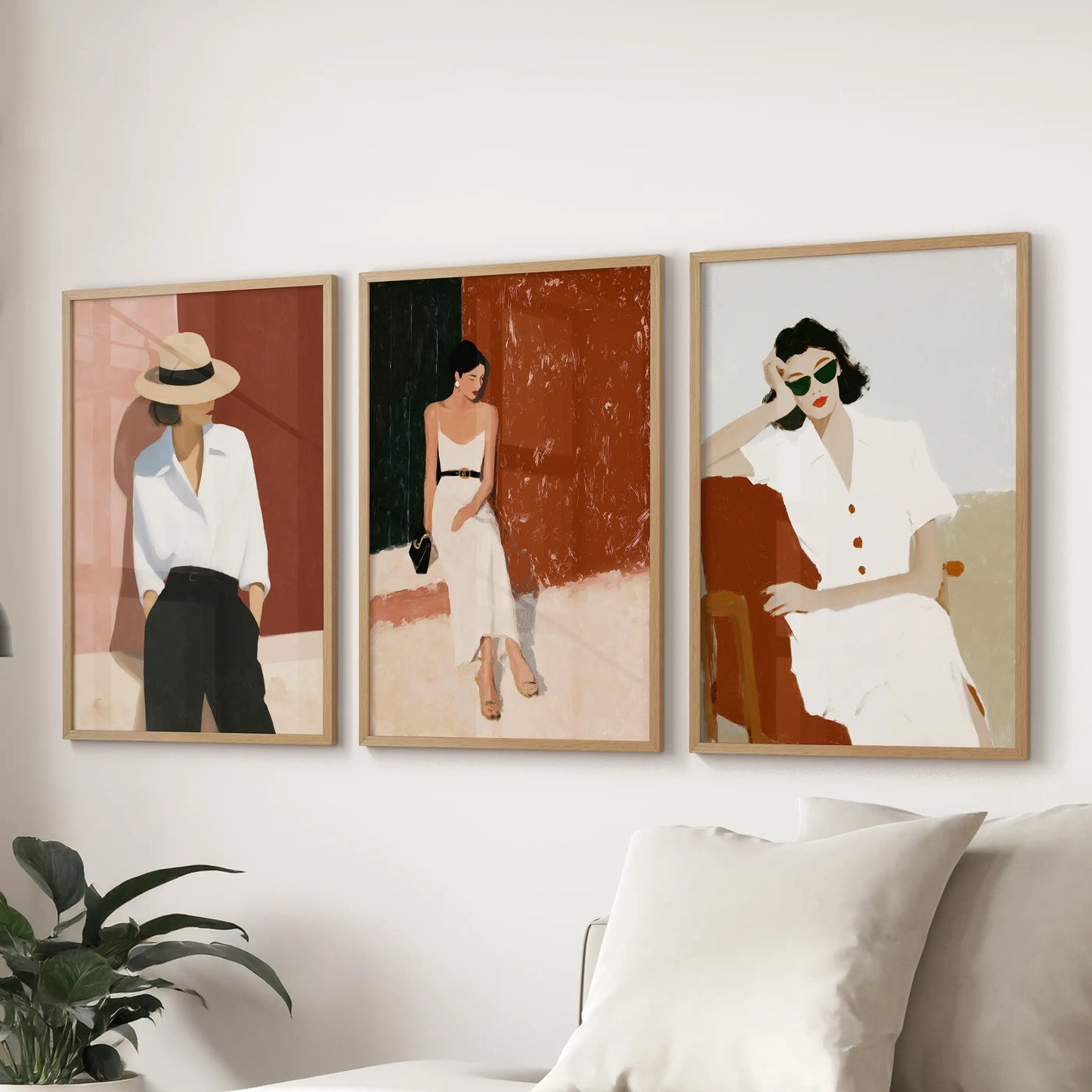 Empowered female figures, a set of three wall prints in natural wood frames, sweep above the sectional sofa to anchor the sitting room.