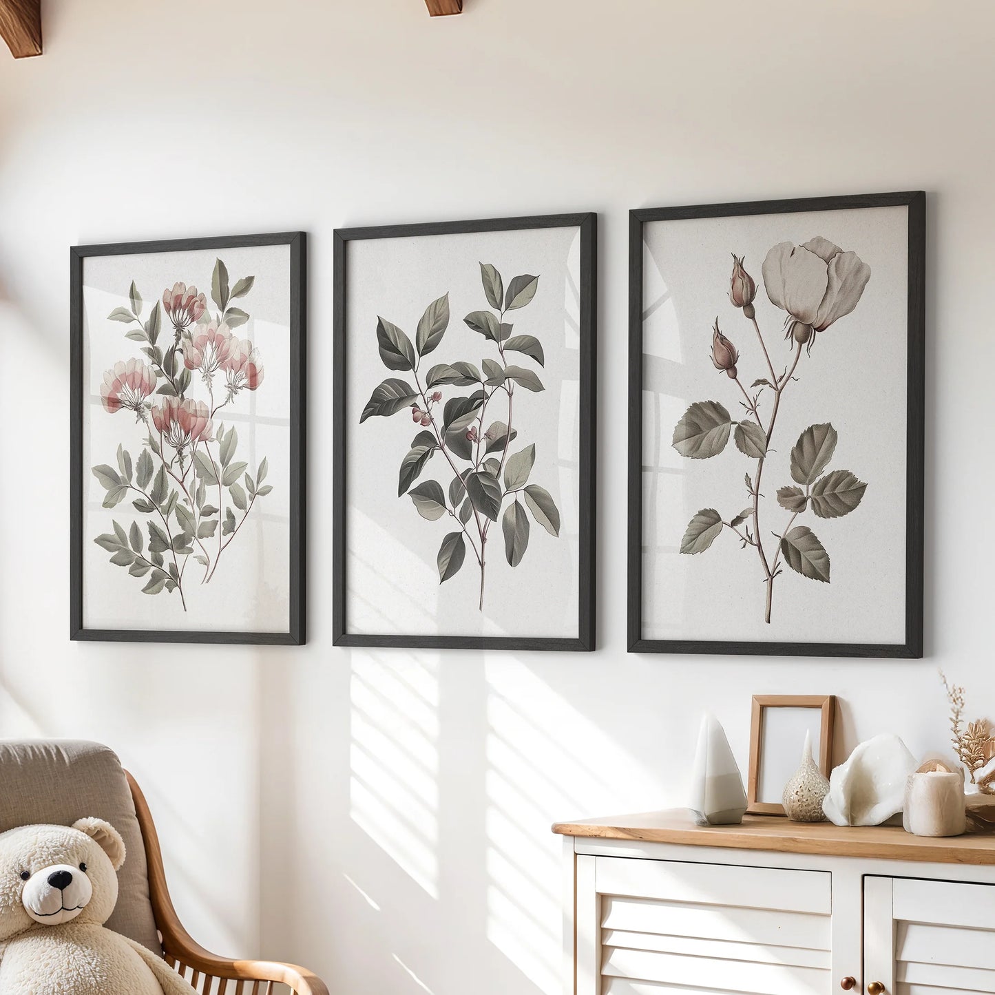 Vintage botanical flower prints, a three-piece wall art set, hang over the chest of drawers in a kids playroom in slim black frames for a cozy, curated feel.