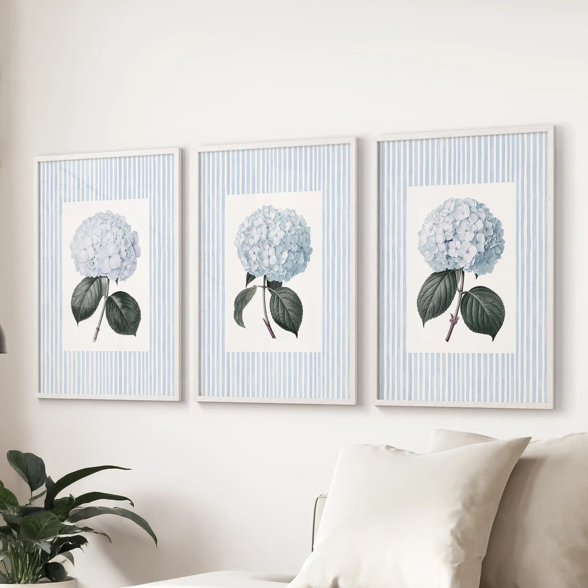 French blue hydrangea three-print wall set in white frames, displayed over a couch in the lounge.