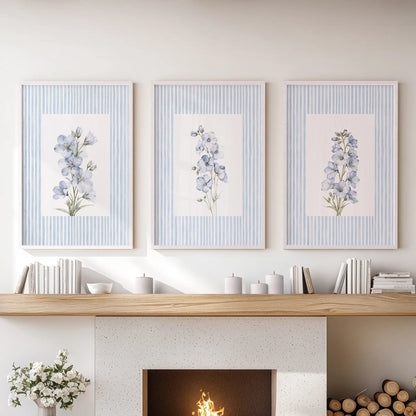 French country flowers 3-print wall art set in white frames, hanging above the fireplace mantel in a lounge.