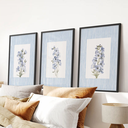 French country floral poster trio in black frames, displayed above the bed against a light blue bedroom wall.